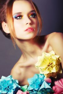 Portrait of Young Beauty with Colorful Origami Flowers. Bright Eye Make-Up